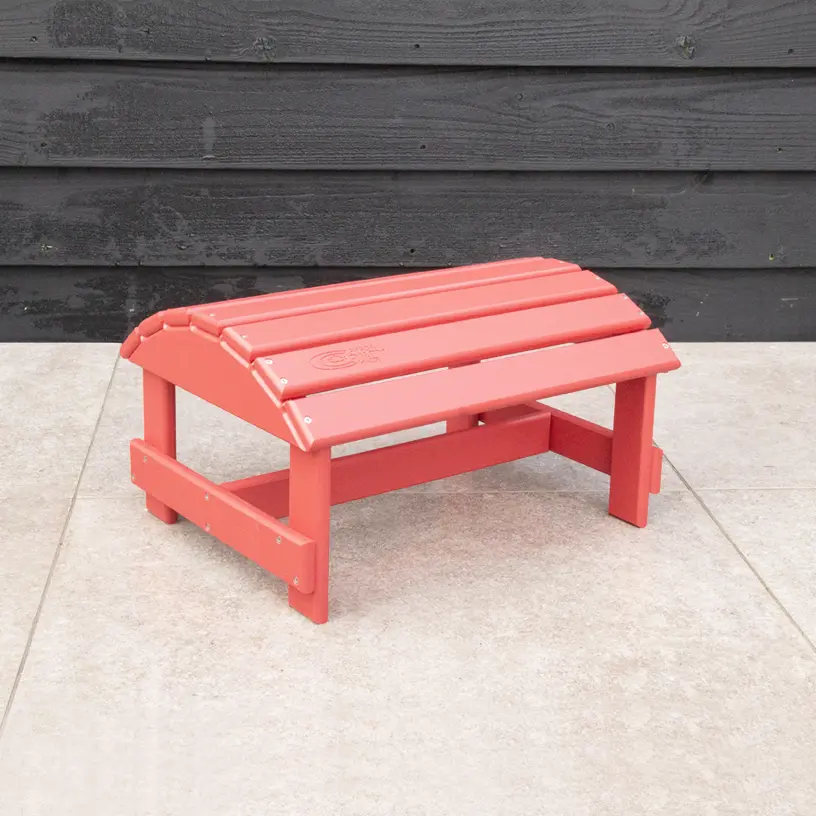 Adirondack voetenbankje gemaakt van duurzaam kunststof in de kleur Pastel rood.